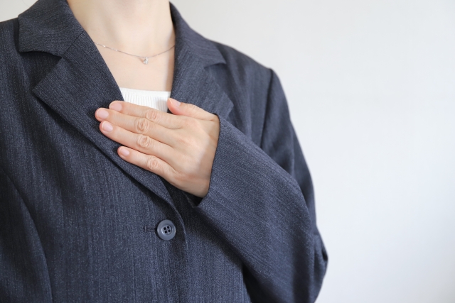 胸を押さえる女性