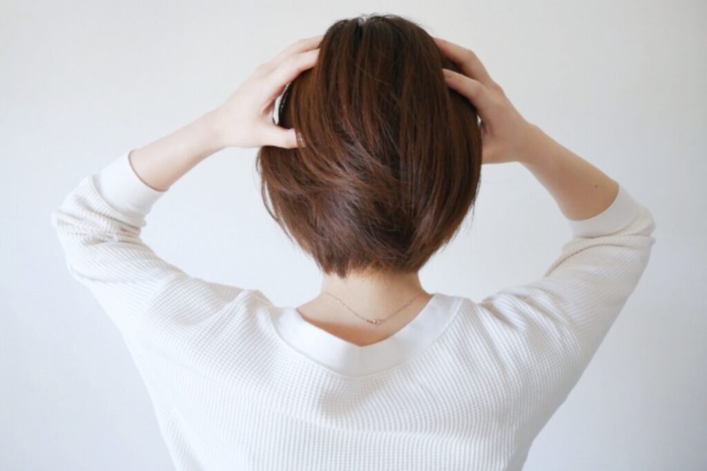頭を触る女性